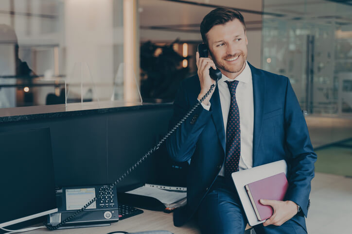 A male executive administrative assistant scheduling a meeting in an office at work