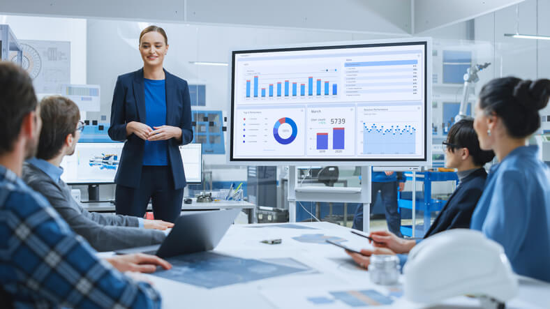 A smiling businesswoman giving a presentation using visual aids after completing her corporate training