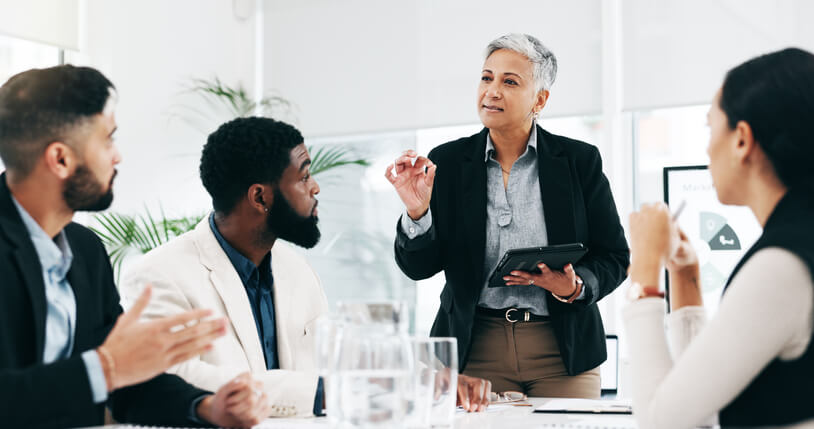 A businesswoman giving a presentation in a boardroom after completing her corporate training