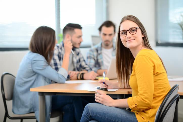 A career college student sitting at a table with classmates